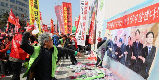 지난 2월 정부세종청사 국토교통부 앞에서 3기신도시 반대연합회 주민들이 3기 신도시 백지화를 요구하며 김현미 국토부 장관과 해당 지역자치단체장의 3기신도시 발표 사진에 물주머니를 던지고 있다.<연합뉴스>